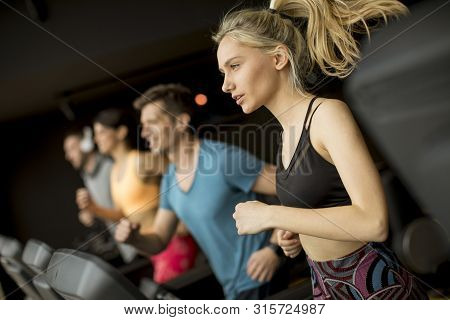 Young People Using Threadmill In Modern Gym