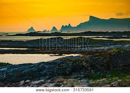 Seascape On Andoya Island. Scenic Rocky Coastline With Mountain Peaks In Distance, View From Bukkekj
