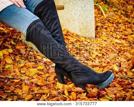 Woman Wearing Long Black Heeled Knee High Boots And Jeans. Autumn Fashion, Warm Footwear Boots.