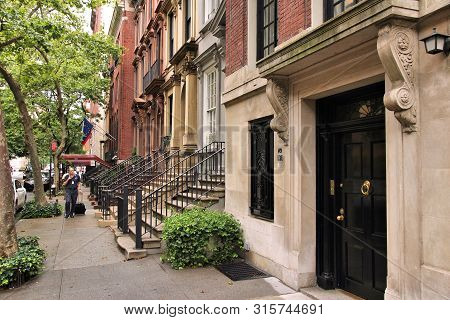 New York, Usa - July 3, 2013: People Walk By New York Brownstone Townhouses In Turtle Bay Neighborho