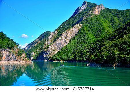 The Touristic Boat Between Green Mountains In Komani Lake