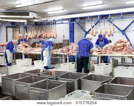Cutting Meat In Slaughterhouse At The Meat Manufacturing.