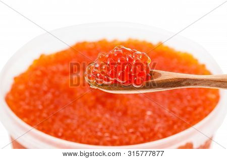 Little Wooden Spoon With Salted Russian Red Caviar Of Sockeye Salmon Fish With Blurred Plastic Conta