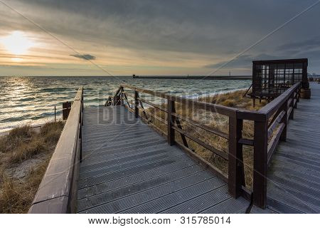 Hel, Poland- 31 January 2015: Wooden Pier On The Dunes At The Beach In The City Of Hel. Groin And Ba