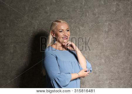 Portrait Of Beautiful Mature Woman On Grey Background