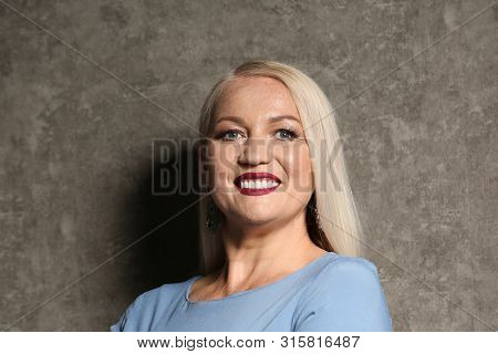 Portrait Of Beautiful Mature Woman On Grey Background