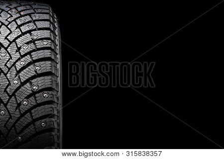 New Winter Studded Tire, Safety And Premium Quality. Black Background, Close-up
