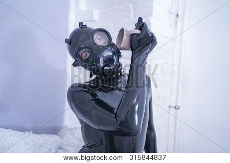 Morning Cup Of Tea Breakfast. Fetish Male In Rubber Black Suit At White Windowsill.