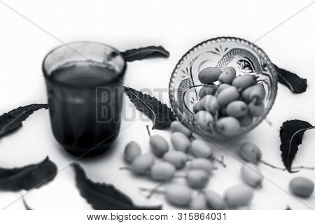 Detox Or Detoxifying Drink Of Neem Fruit In A Glass Isolated On White Along With Some Neem Fruit Or