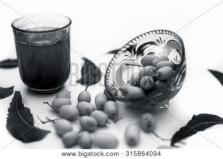Detox Or Detoxifying Drink Of Neem Fruit In A Glass Isolated On White Along With Some Neem Fruit Or