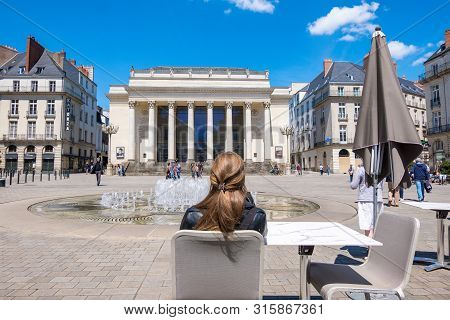 Nantes, France - May 12, 2019: Beautiful Woman Resting At An Outdoors Cafe On The Place Graslin Near