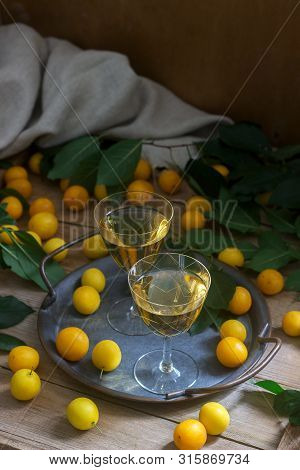 Cherry Plum Liqueur In Small Glasses And Cherry Plum On A Wooden Background. Rustic Style.