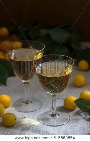 Cherry Plum Liqueur In Small Glasses And Cherry Plum On A Wooden Background. Rustic Style.