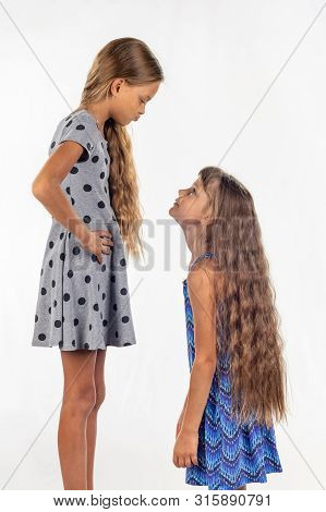 Two Girls Of Different Stature, One Stood On A Chair And Became Even Taller