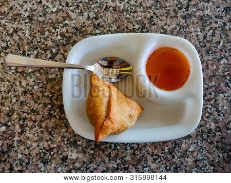 Samosa With Chutney Or Sauce Served In A White Plate. Top View