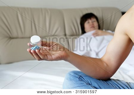 Couple In A Bed Before Sex, Man Takes Pills For Erection. Concept Of Sexual Issues, Viagra, Contrace