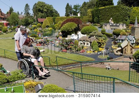 Beaconsfield, Uk - June 27, 2019. A Disabled Woman In A Wheelchair Visits Bekonscot Model Village An