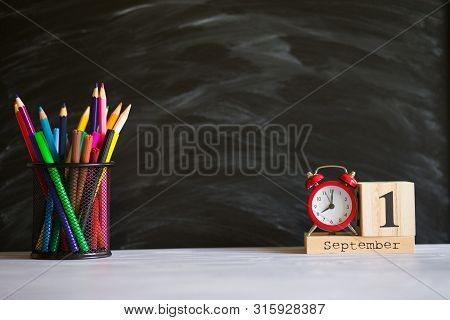 Concept Back To School. Re Alarm Clock With Color Pencils And Wooden Calendar Set On 1St September O