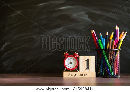 Concept Back To School. Re Alarm Clock With Color Pencils And Wooden Calendar Set On 1St September O