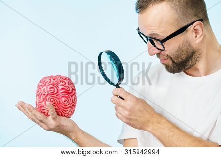 Adult Nerd Man Wearing Eyeglasses Looking At Human Brain Model. Thinking And Intelligence Conept