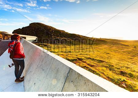 Tourist Woman With Norwegian Flag Enjoying Sea Coast View From Bukkekjerka Rest Stop Area On Andoya 