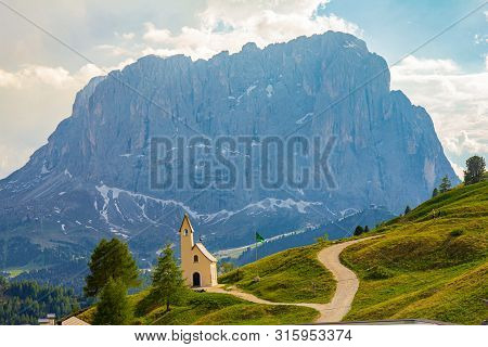San Maurizio Chapel On The Passo Di Val Gardena With Mountain View In Background. Colorful View In P