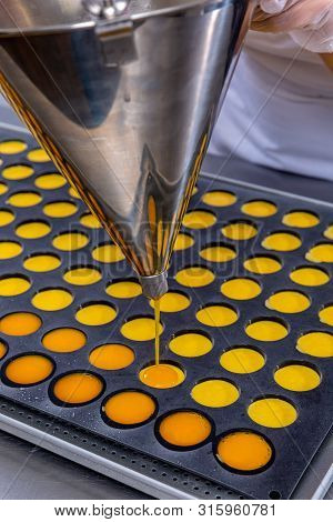 Pastry Chef In The Kitchen Makes Passion Fruit Confit. Cook Pours Passion Fruit Confit Into The Mold