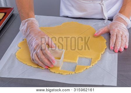 Pastry Chef In The Kitchen Makes Cookies. Cook Cuts Cookies From Rolled Dough Using A Cookie Cutter.
