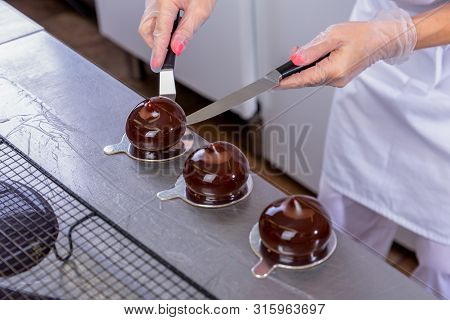 The Pastry Chef In The Kitchen Glazes Pastries. Cook Puts Glazed Cakes On Decorative Coasters. Maste
