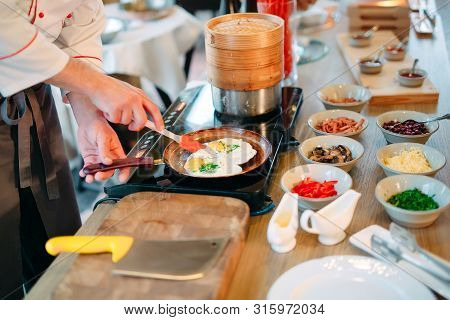 Breakfast. Scrambled Eggs Are Cooked On An Induction Cooker In The Restaurant.
