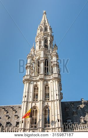 Brussels, Belgium - June 22, 2019: Closeup Of Gray Stone Spire Of City Hall With Belgian Flag On Gra