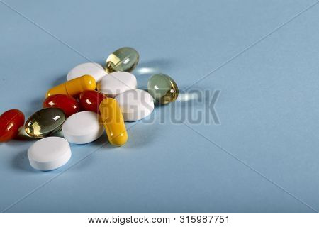 A Lot Of Bright Colored Medicine Pills On A Blue Background. Cropped Shot, Vertical, Side View, Clos