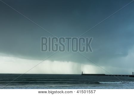 Stürmisches Wetter mit Regenwolken und Leuchtturm in der Sable d ' Olonne in Frankreich