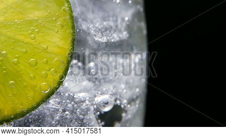 Macro Close-up, Refreshing Soda Tonic Fizzy Water, Lime In Glass, Ice. Slice Of Lemon, Mineral Bubbl