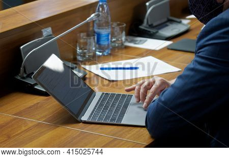 A Man - A Businessman, Official, Accountant Or Lawyer, Uses The Touchpad Of A Small Laptop While Sit