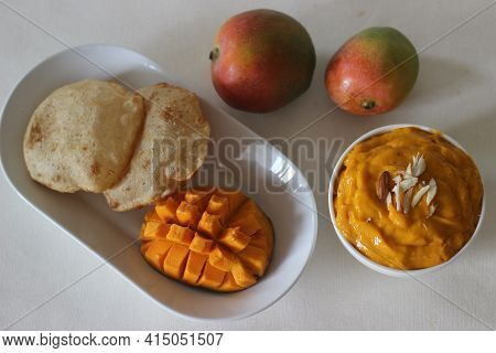 Deep Fried Indian Flat Bread Served With Mango Pulp Locally Known As Aamras. Mango Pulp Is Made From