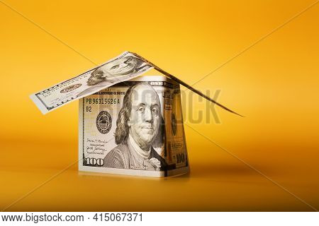 House Made From 100 Dollar Bills Cash Money On Yellow Background.