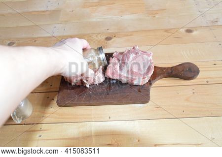 Salted And Peppery Steak Lies On A Wooden Stand