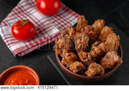 Buffolo Wings Close-up In Ceramic Bowl With Tomato Sauce And Tomatoes