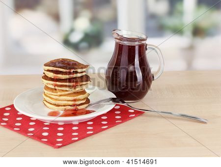หวาน pancakes บนแผ่นกับแยมบนโต๊ะในห้องครัว