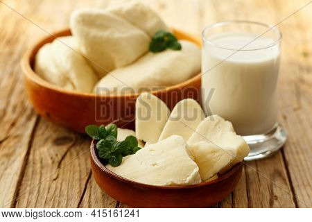 Cypriot Semi-hard, Fresh Homemade Unripened Brined Cheese Halloumi In Wooden Plates And Milk. Popula