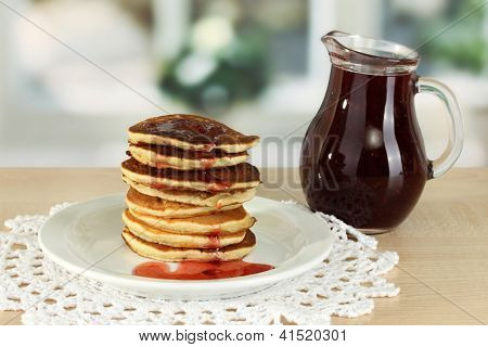 หวาน pancakes บนแผ่นกับแยมบนโต๊ะในห้องครัว