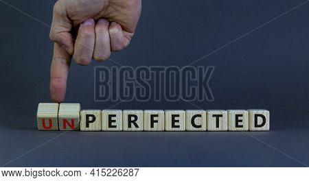 Perfected Or Unperfected Symbol. Businessman Turns Wooden Cubes And Changes The Word Unperfected To 