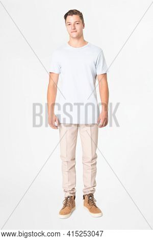 Man in white t-shirt and beige slacks full body