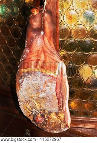 Home Made Traditional Croatian Hamon Hanging On A Vintage Cellar Door. Traditional Mediterranean Cui