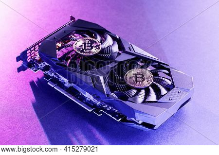 Two Gold Bitcoin On A  Video Card With Purple Backlight In The Style Of Cyberpunk. Crypto Currency.