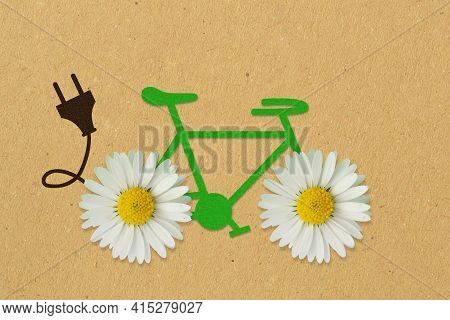 Green Paper Bicycle With Daisy Flowers And Electric Plug On Recycled Paper Background - Concept Of E