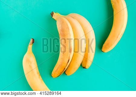 Fresh Tasty Yellow Bananas On Green Mint Background. Healthy Food Concept. Minimal Concept
