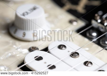 Guitar Fretboard With Tuning Pegs And Strings On A Gray Background. Close-up