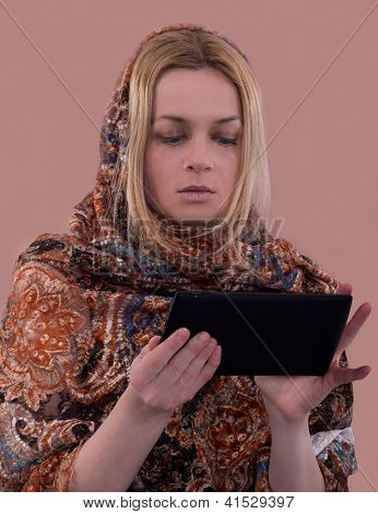 kvinde med orientalsk headkerchief ved hjælp af tablet, traditionelle og moderne,